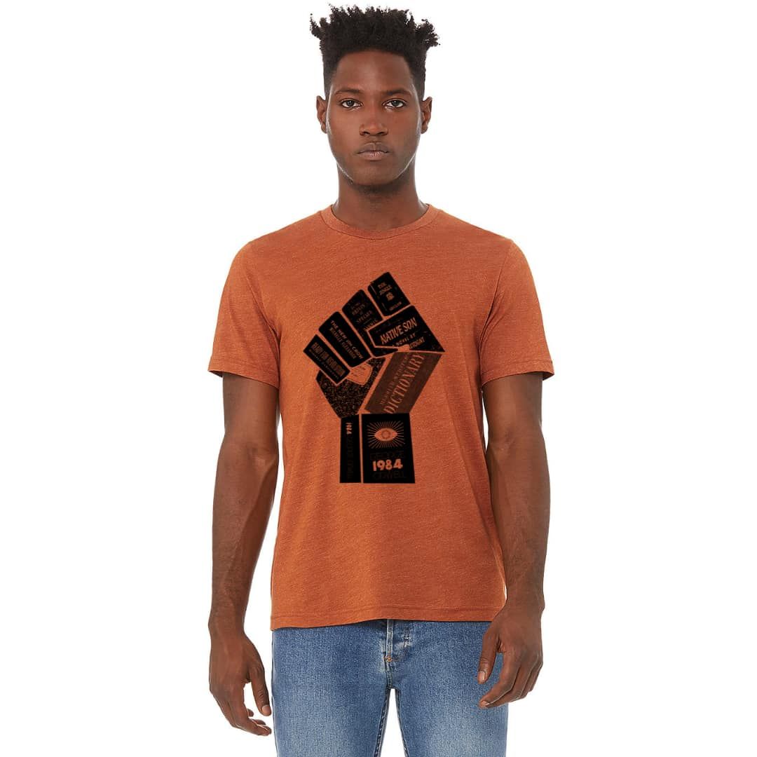 Man wearing orange t-shirt with a black fist design and holding books.
