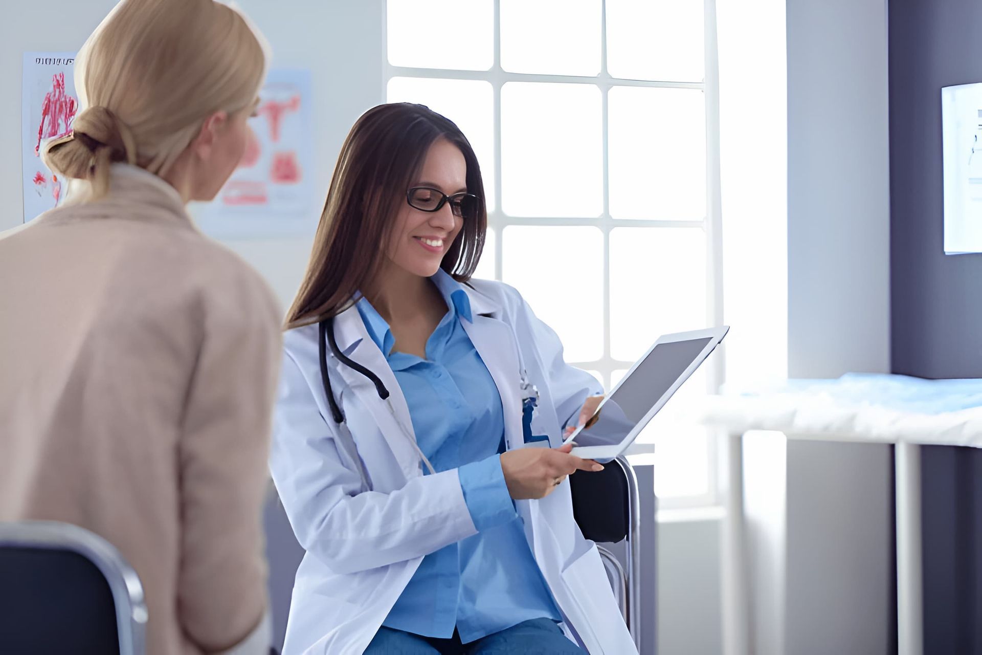 A Doctor is Talking to a Patient While Holding a Tablet — Eastcoast Women's Centre in Rockhampton, QLD