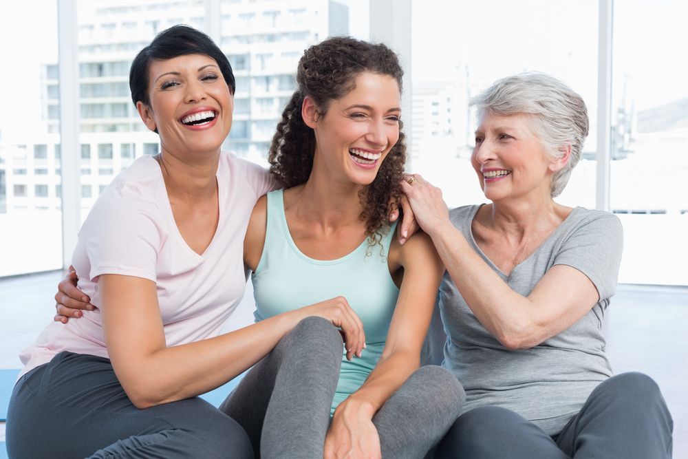 Three Women Are Sitting Next to Each Other on a Couch and Smiling — Eastcoast Women's Centre in Nambour, QLD