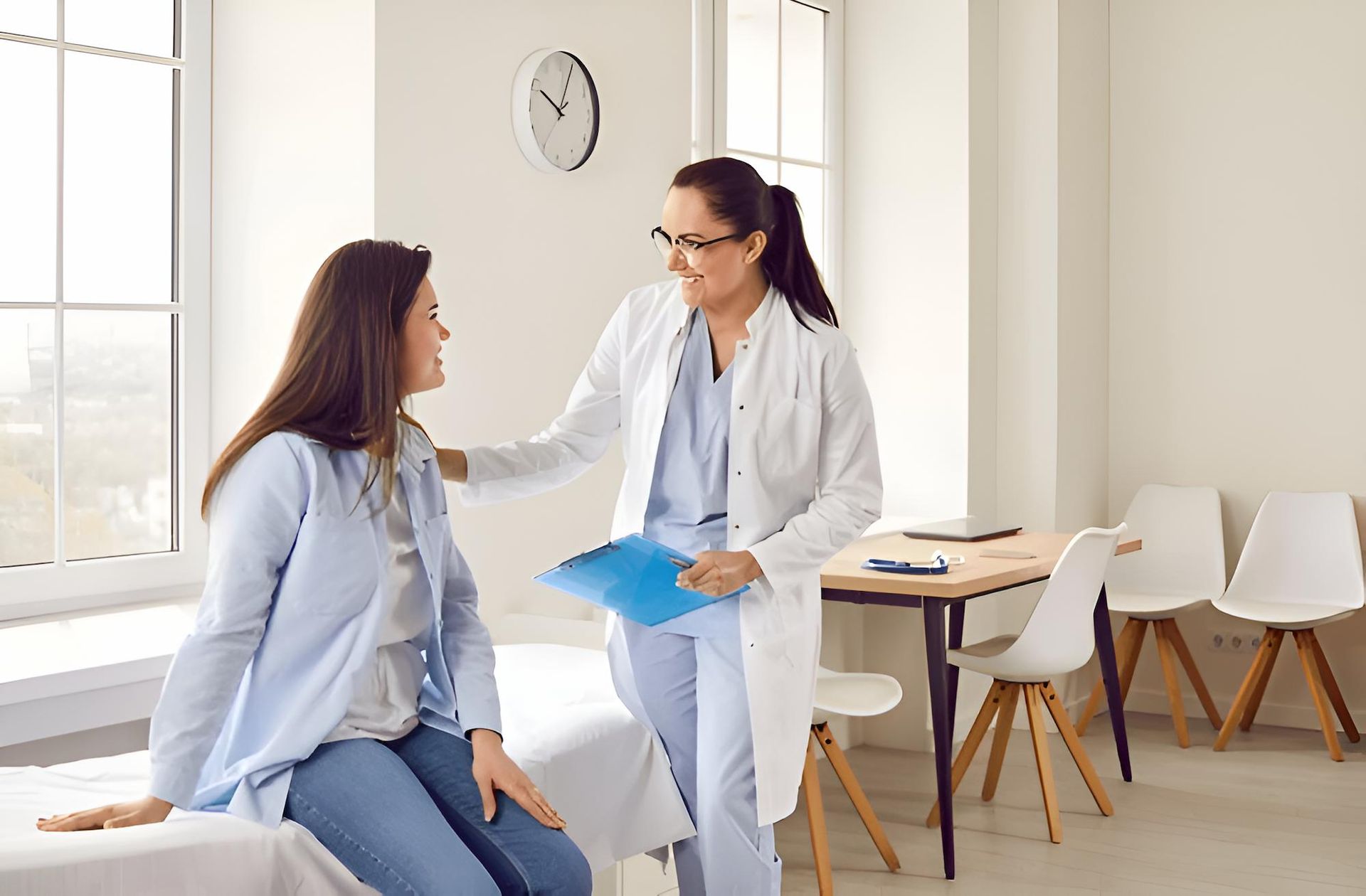 A Doctor is Talking to a Patient Who is Sitting on a Bed — Eastcoast Women's Centre in Nambour, QLD