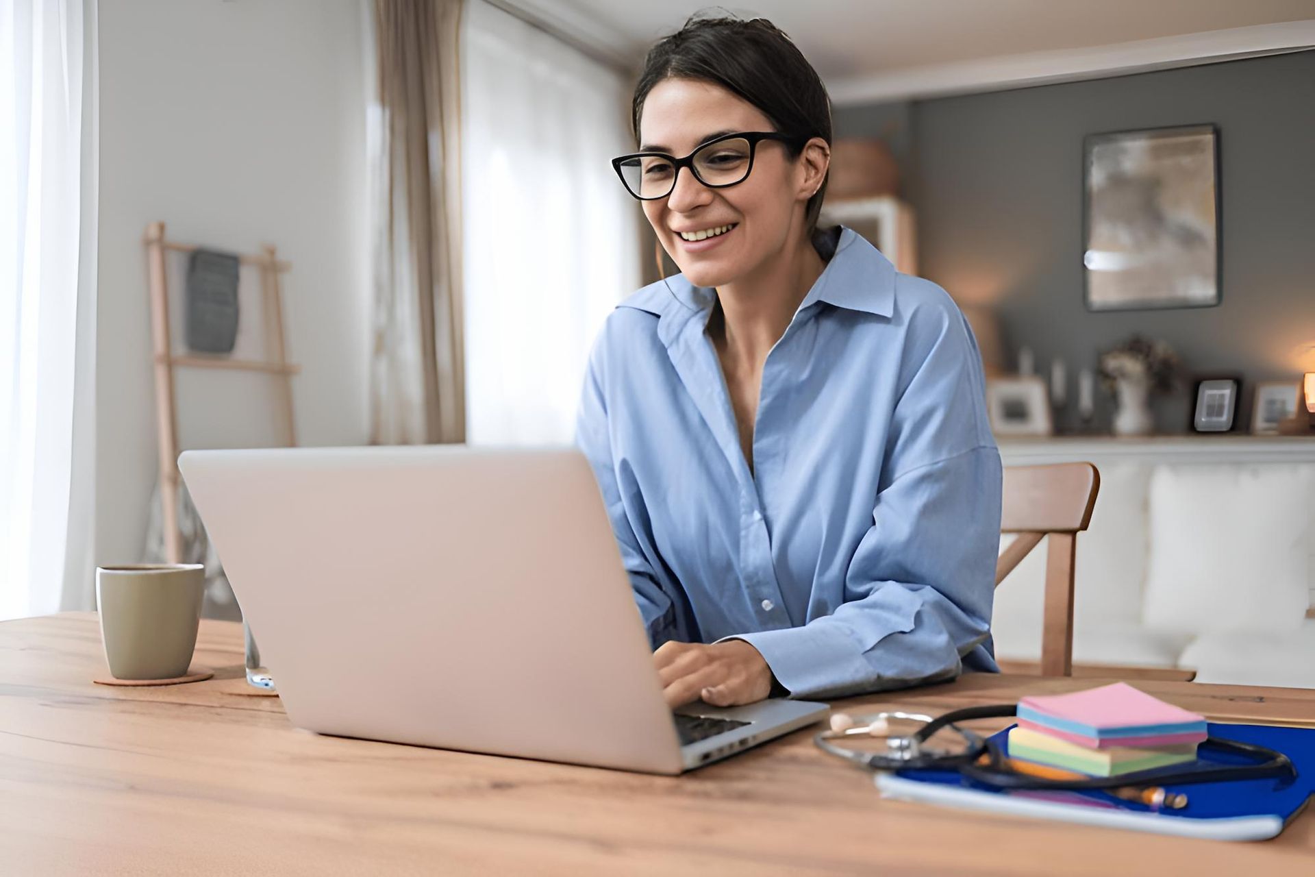 A Woman is Sitting at a Table Using a Laptop Computer — Eastcoast Women's Centre in Townsville, QLD