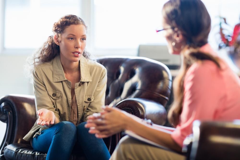 Woman in Jeans and Jacket Talking to a Therapist — EastCoast Women's Centre In Gladstone, QLD