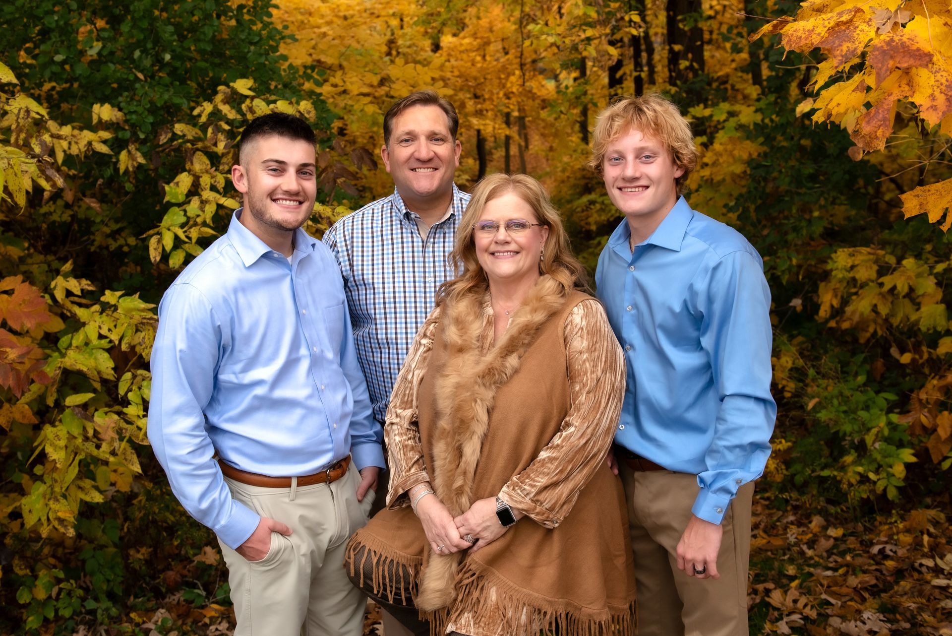 An aerial view of a lush green field with trees and a road at sunset.