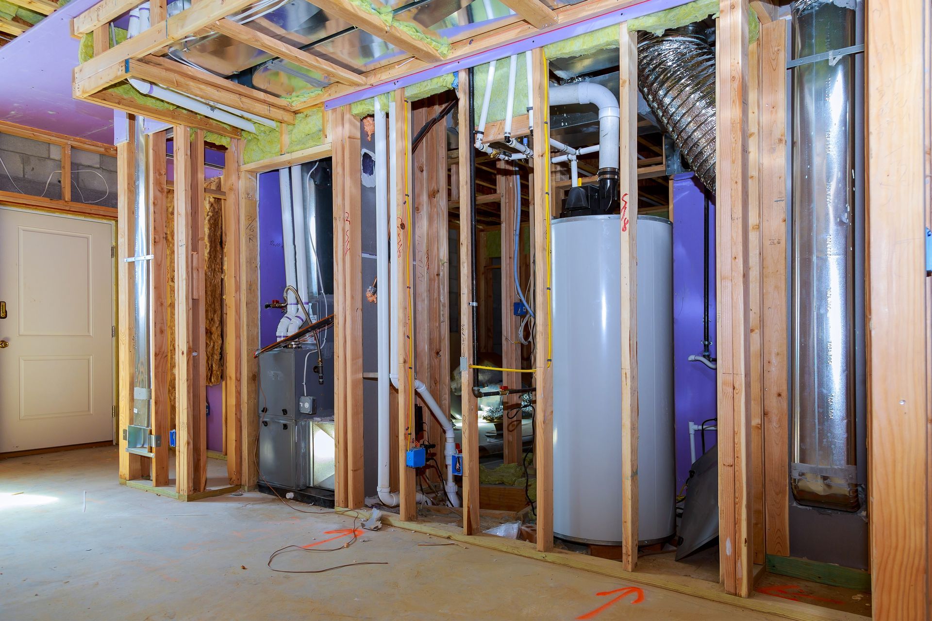 Interior view of a basement under construction, revealing framing, HVAC systems, and a water heater against purple walls.