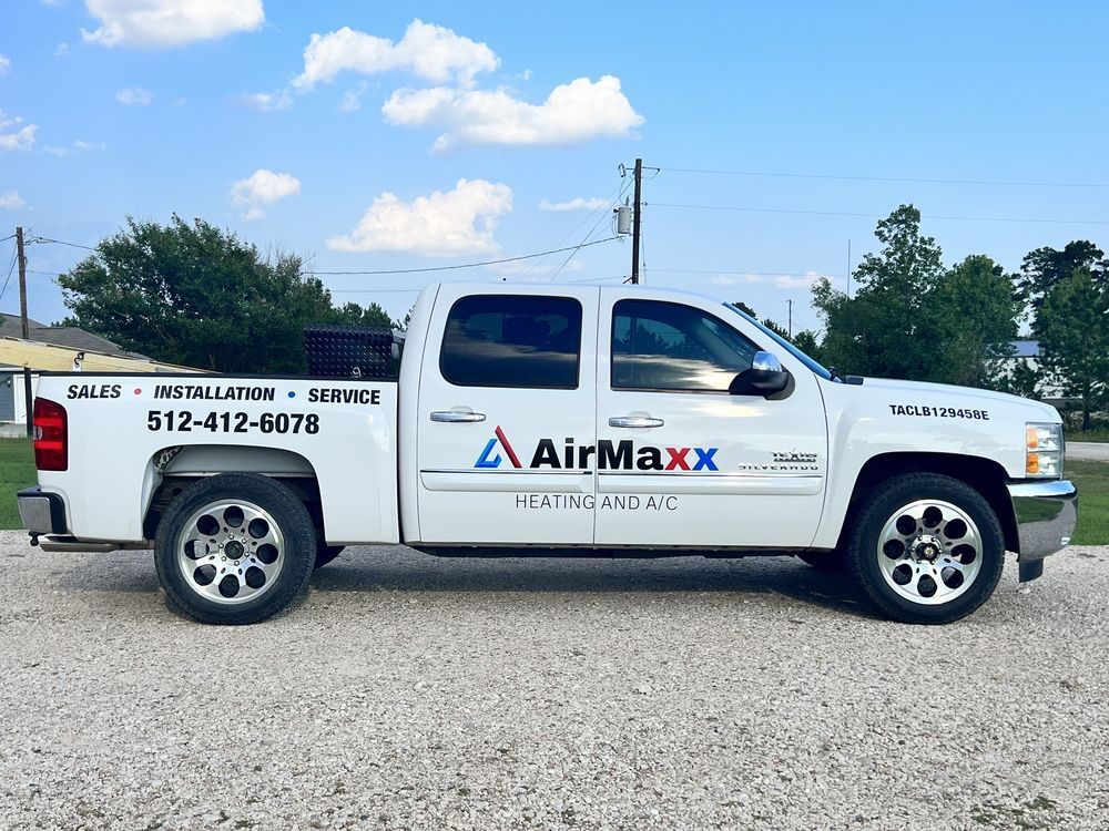 White AirMaxx service truck parked outside. Text on the side includes phone number, and service types.