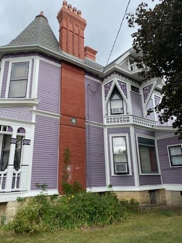 A large purple house with a red chimney on the roof.
