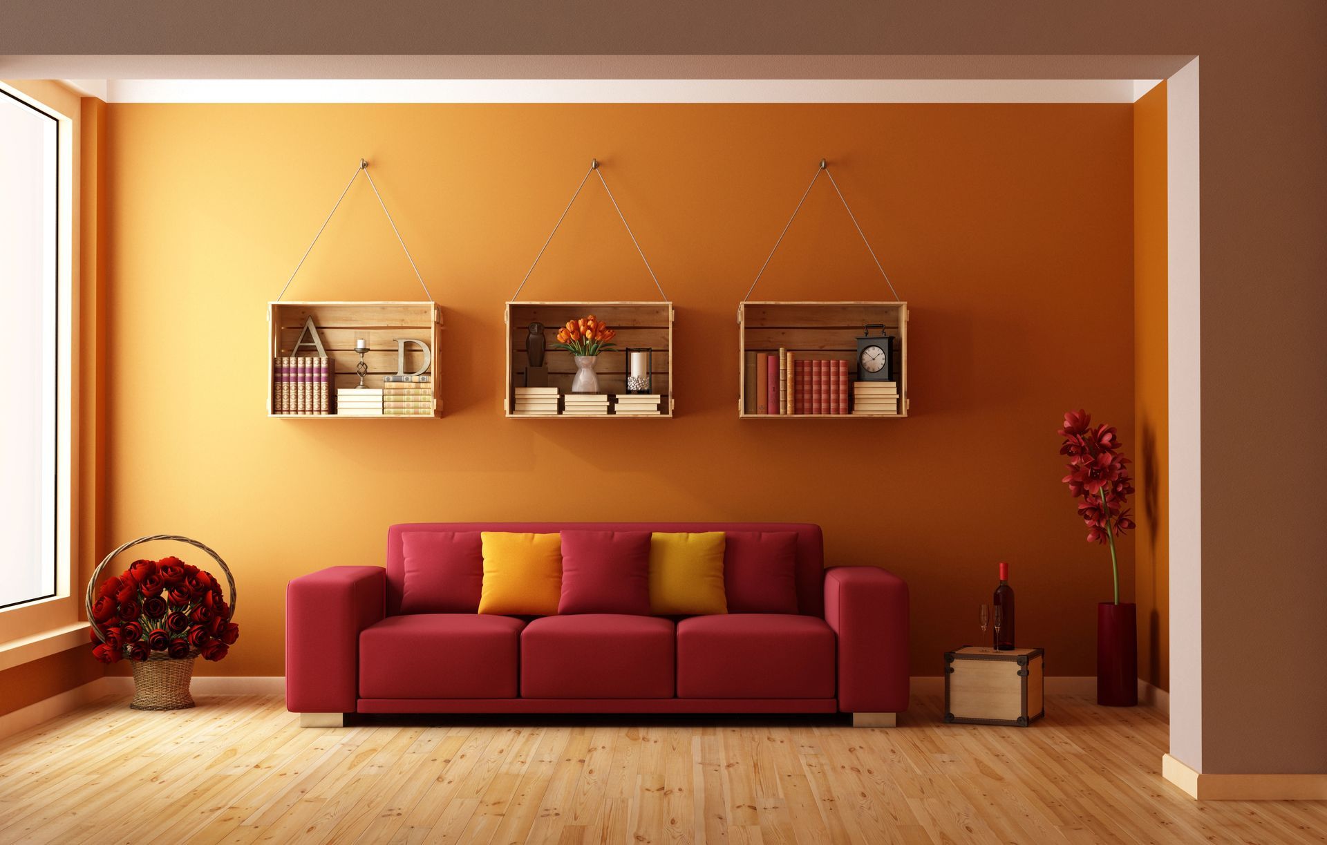 Red sofa in a room with orange walls, wooden shelves with books, and a large window.