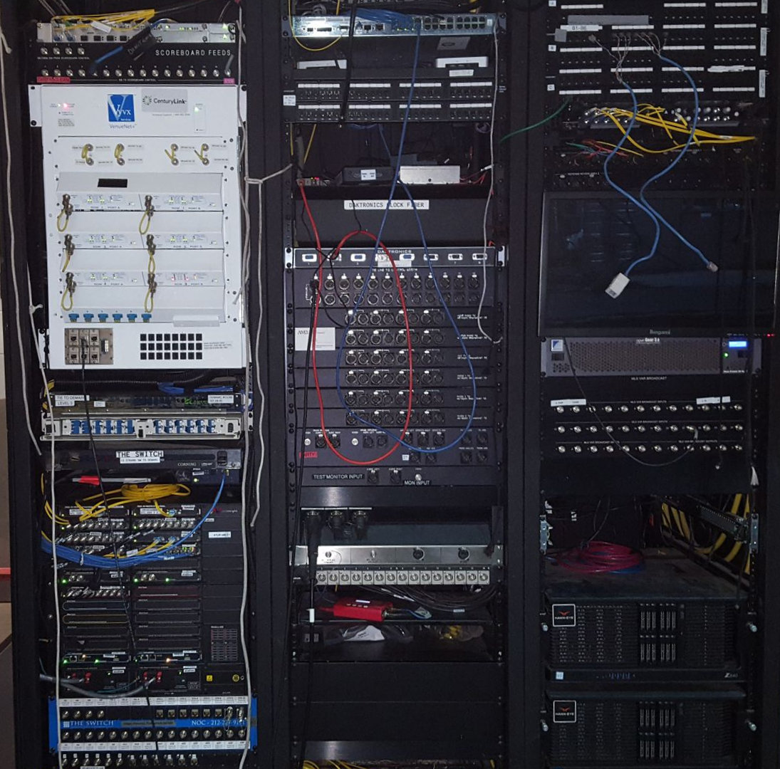 Office reception area with black desk, waiting chairs, and a monitor.