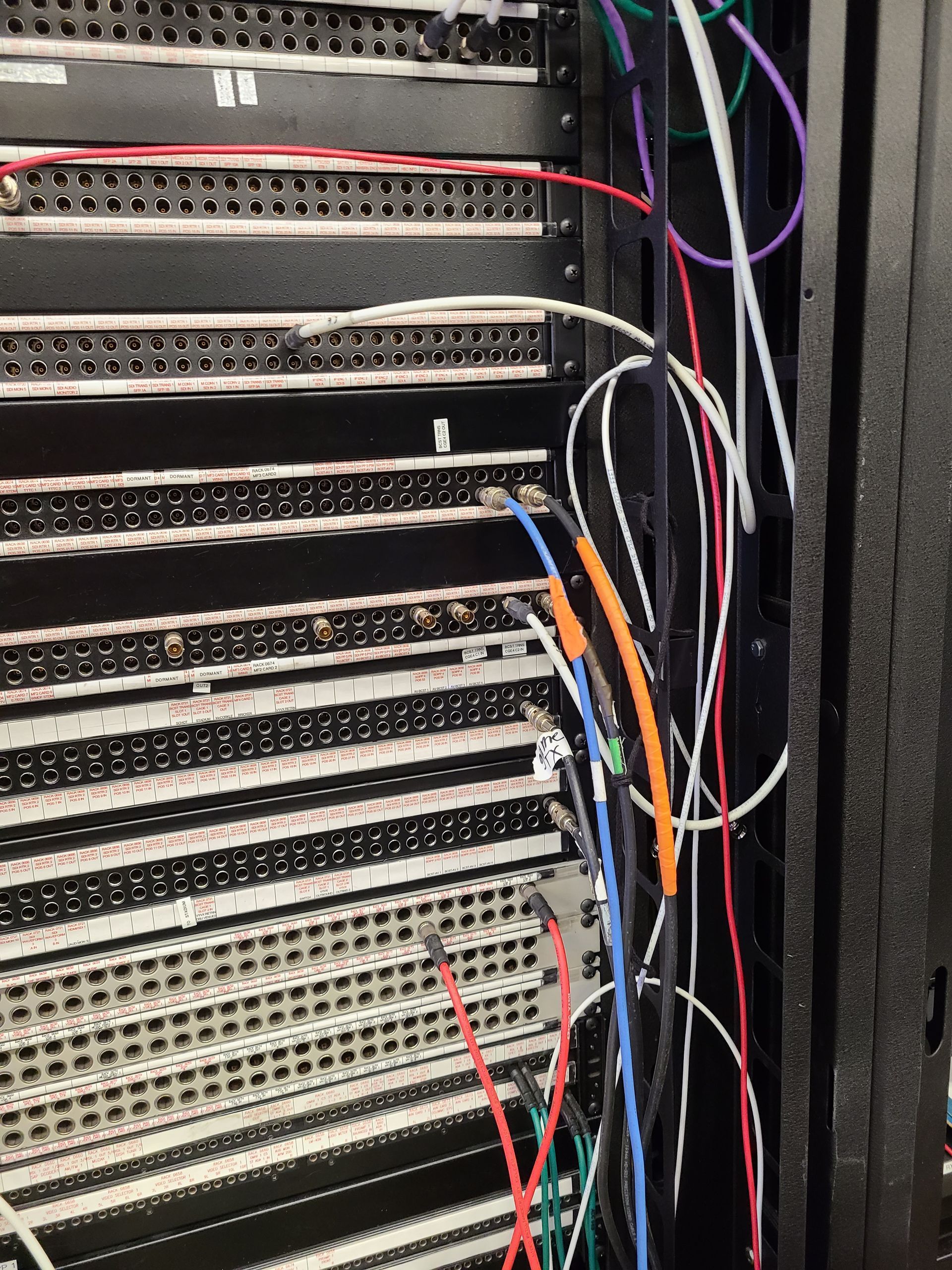 Man in yellow hard hat installs a satellite dish on a rooftop in sunlight.
