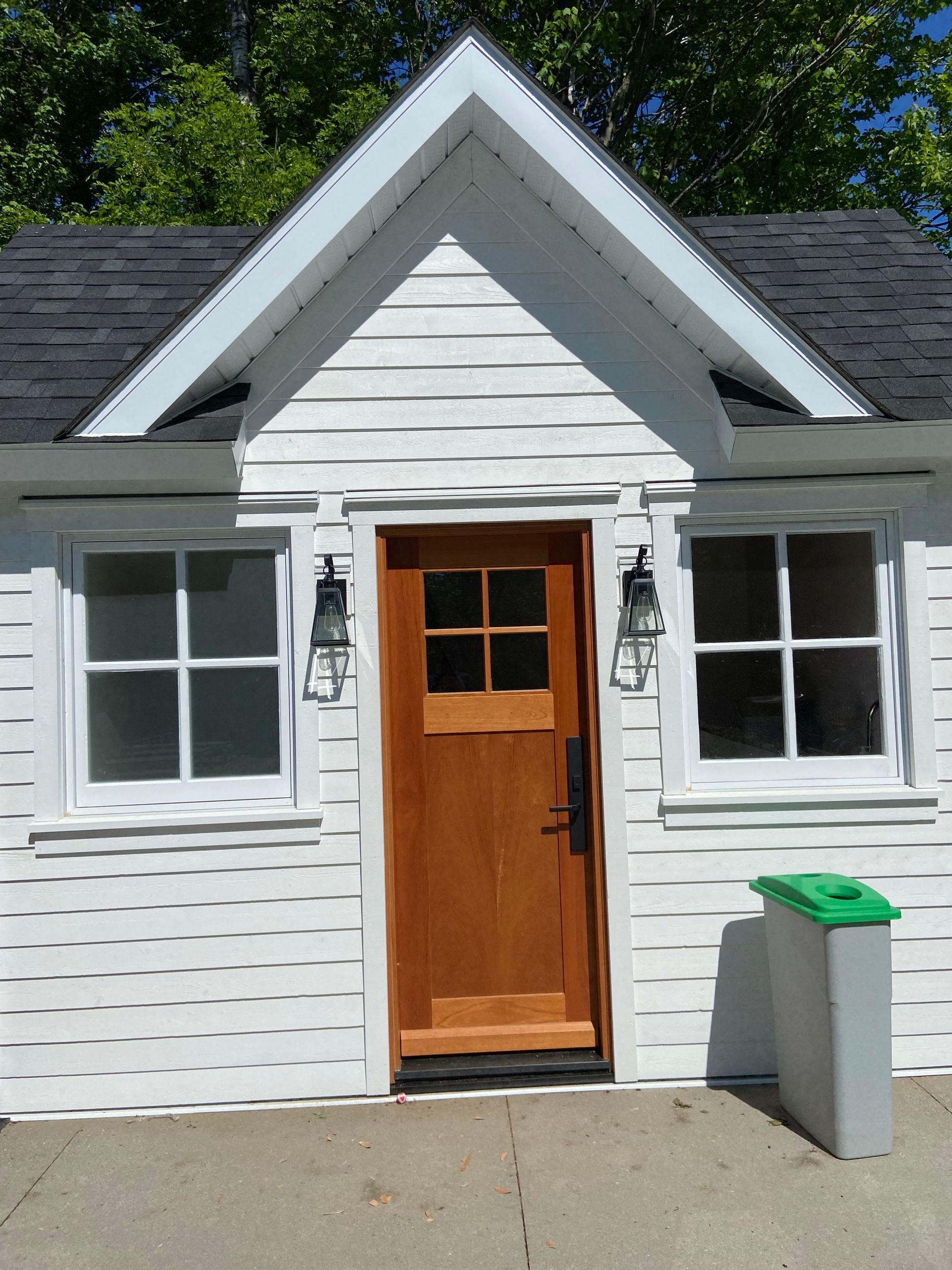 Une petite maison blanche avec une porte en bois