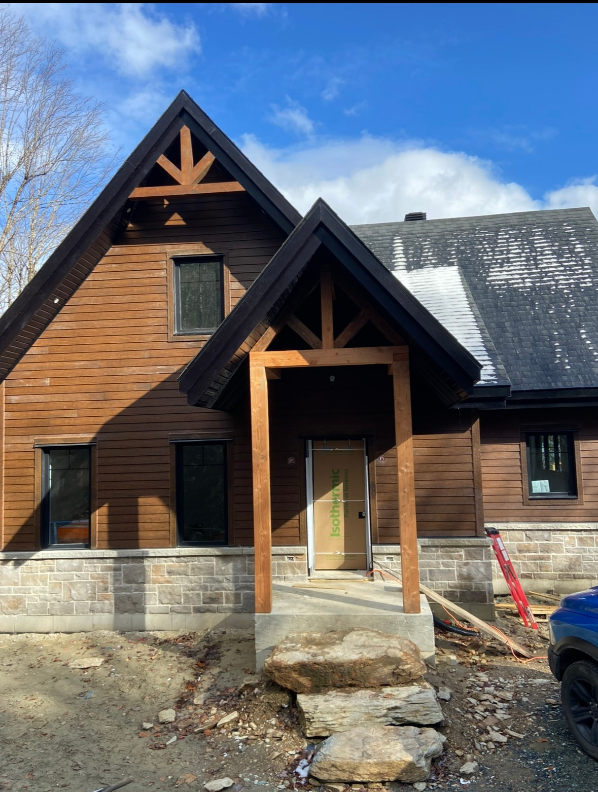 Une maison en bois avec un toit noir est en construction