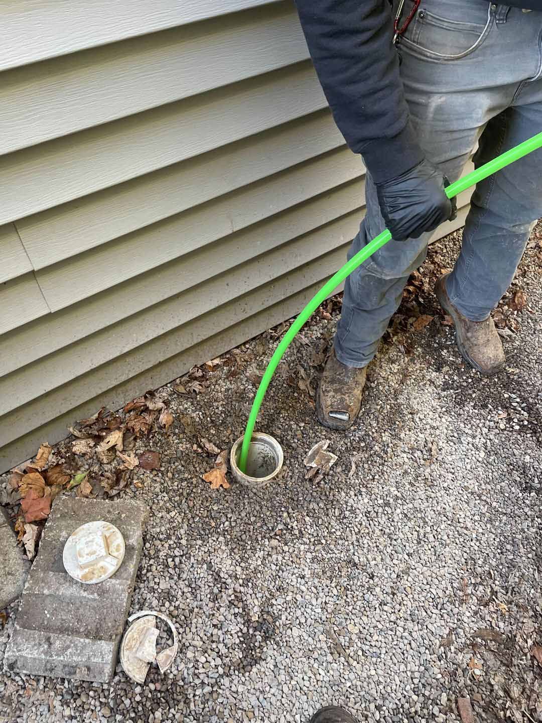 Cleaning the pipe using a green hose — Farmersville, OH — Moore Sewer Services