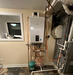White wall-mounted boiler with copper pipes in a basement.