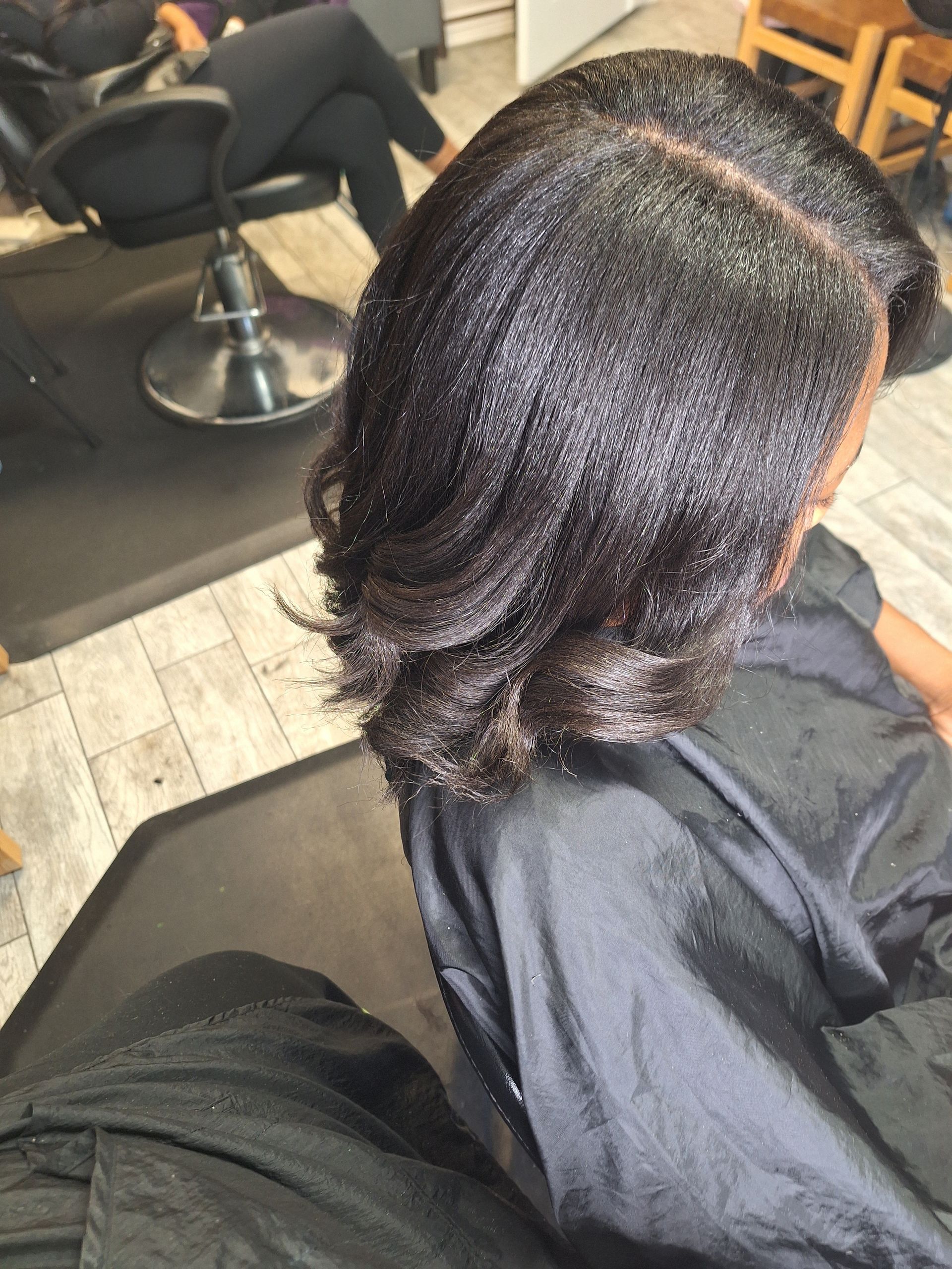 A woman is getting her hair cut in a salon.