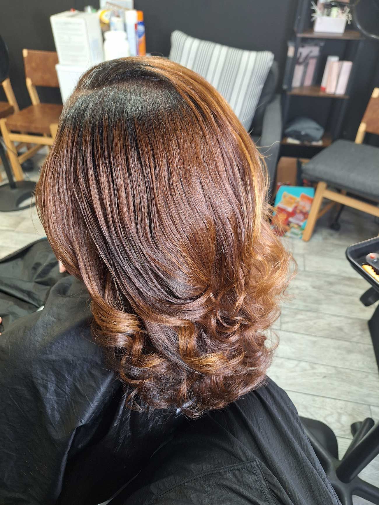A woman is getting her hair cut in a salon.