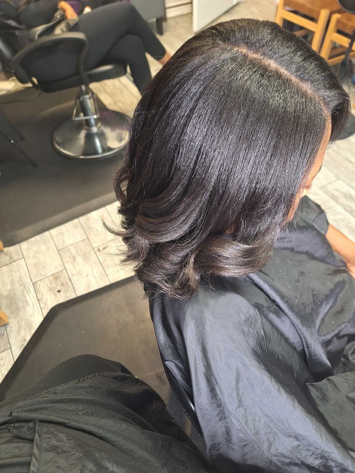 A woman is getting her hair cut in a salon.