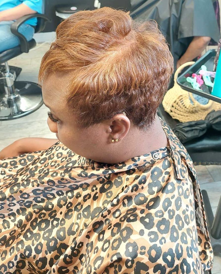 A woman is getting her hair cut in a salon.