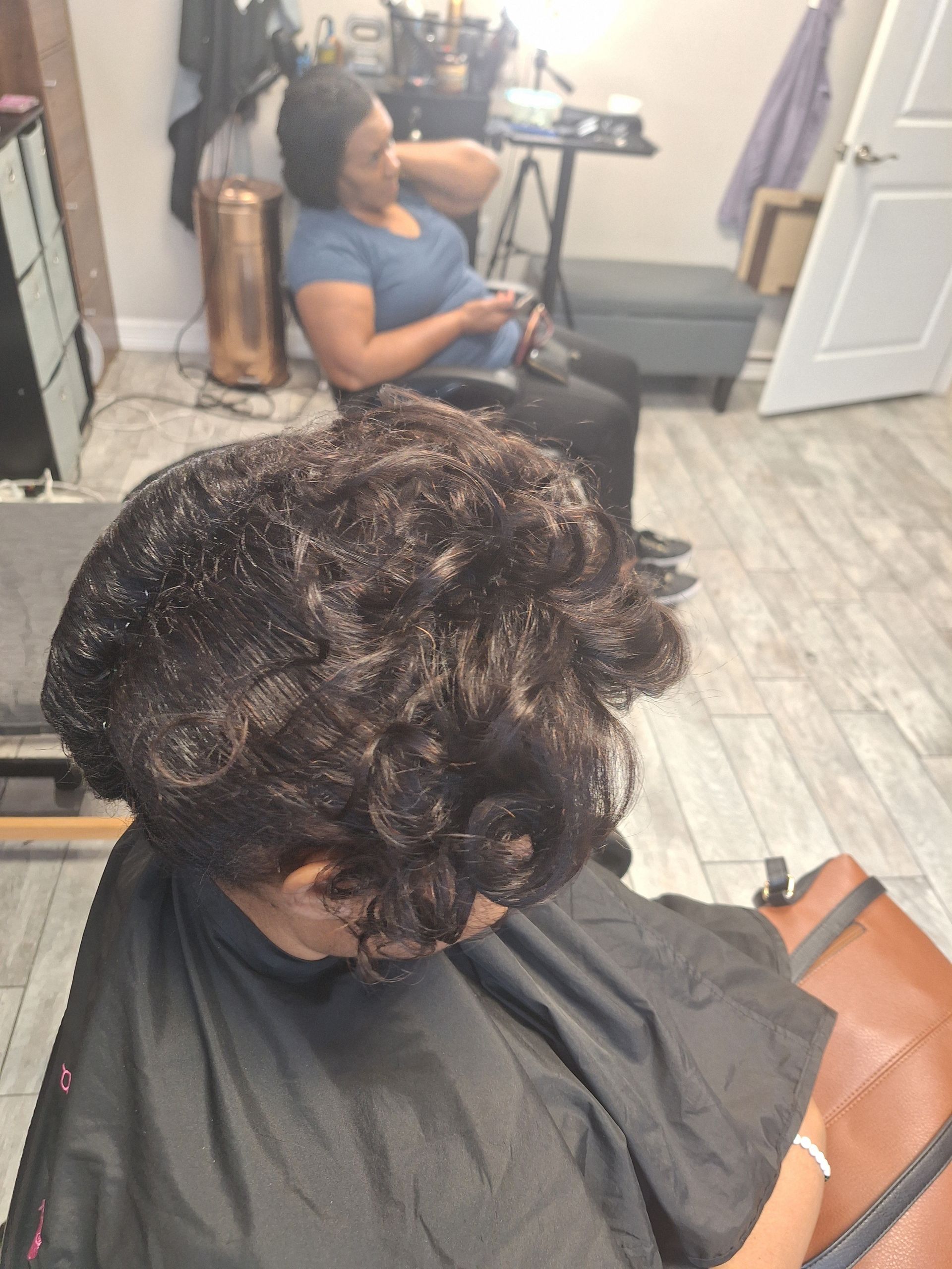 A woman is getting her hair cut in a salon.