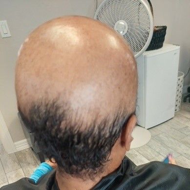 A man with a bald head is sitting in a chair