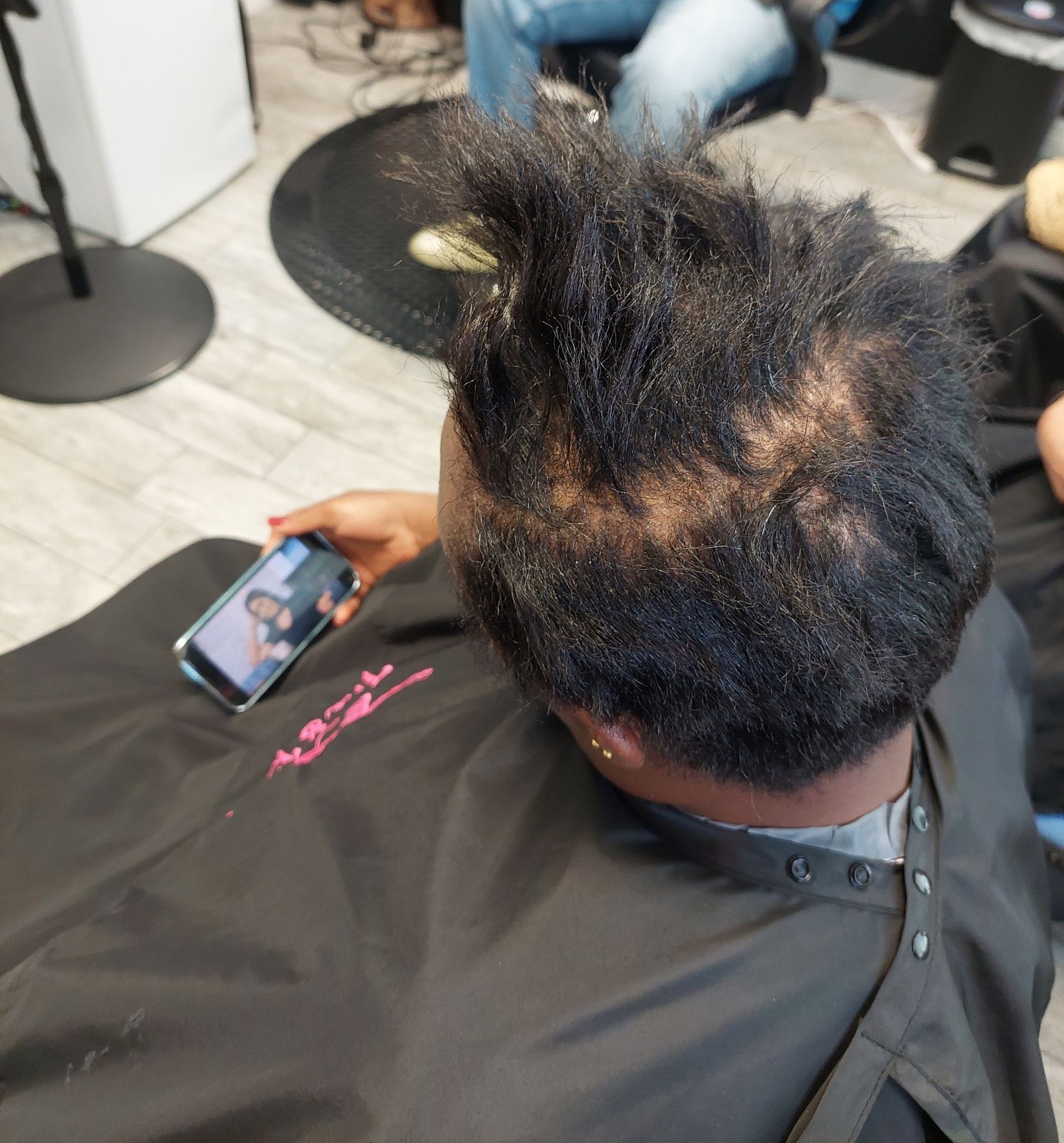 A woman is sitting in a chair holding a cell phone.