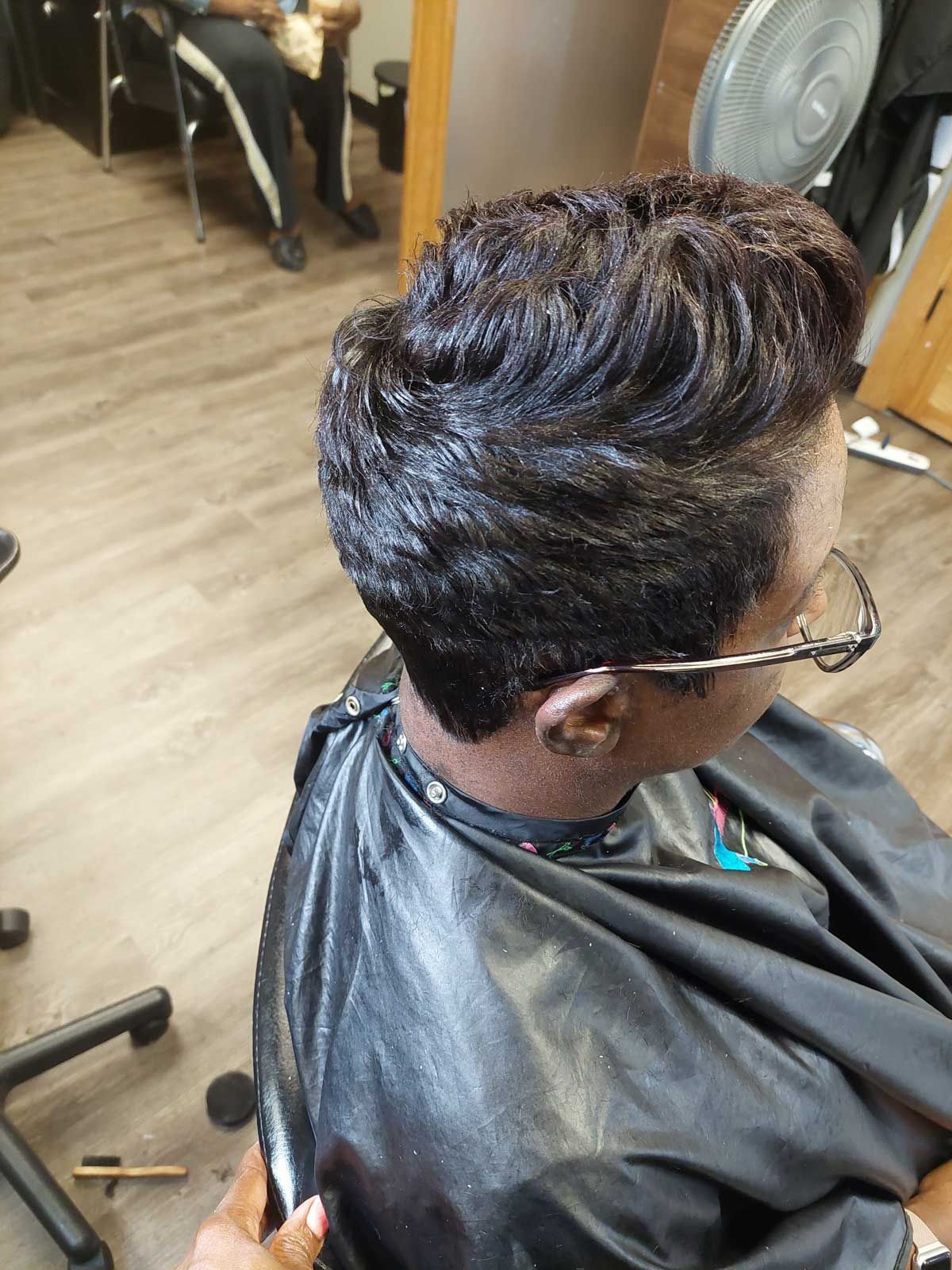 A woman is getting her hair cut in a salon.