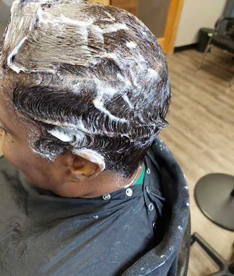 A woman is getting her hair dyed in a salon.