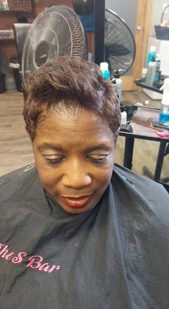 A woman is getting her hair cut in a salon.