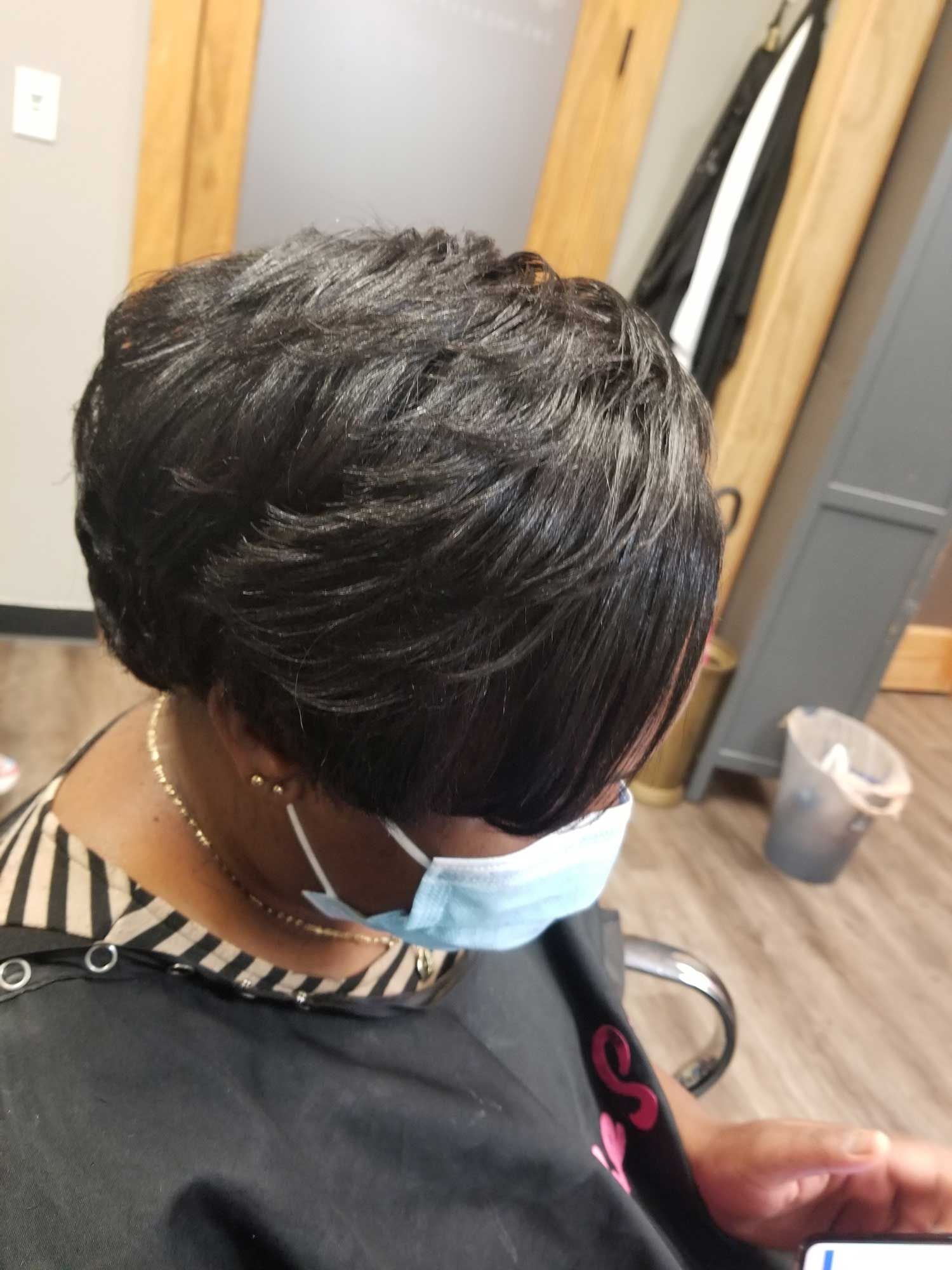 A woman wearing a face mask is sitting in a chair.