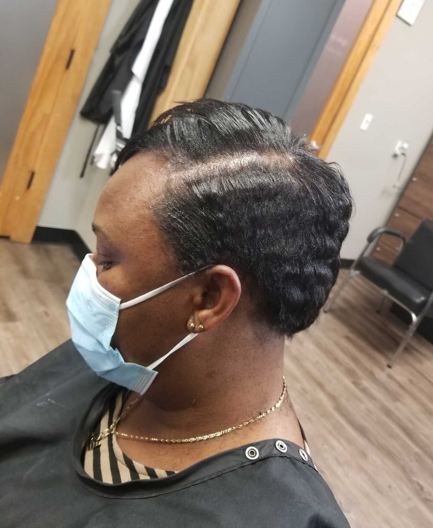 A woman wearing a face mask is sitting in a chair.