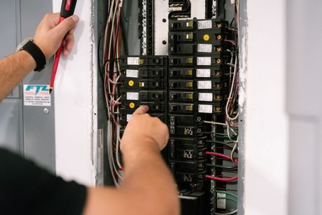 A close up of a electrical box with a lot of wires coming out of it.