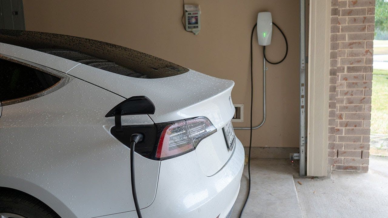 A tesla model s is being charged at a charging station.