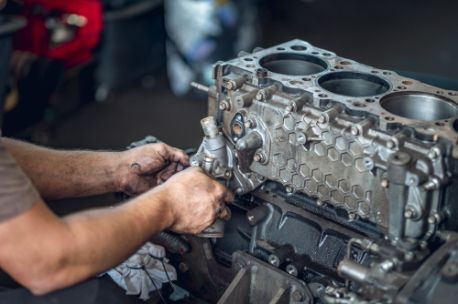 A Man is Working on a Car Engine in a Garage — Border Power Steering Service In Lavington, NSW