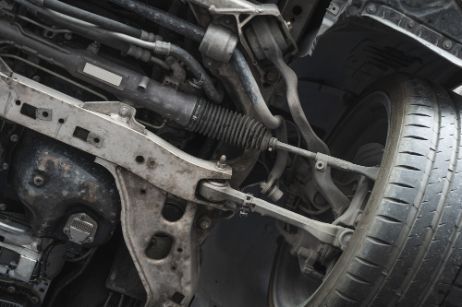 A Close Up of the Underside of a Car With a Tire — Border Power Steering Service In Lavington, NSW