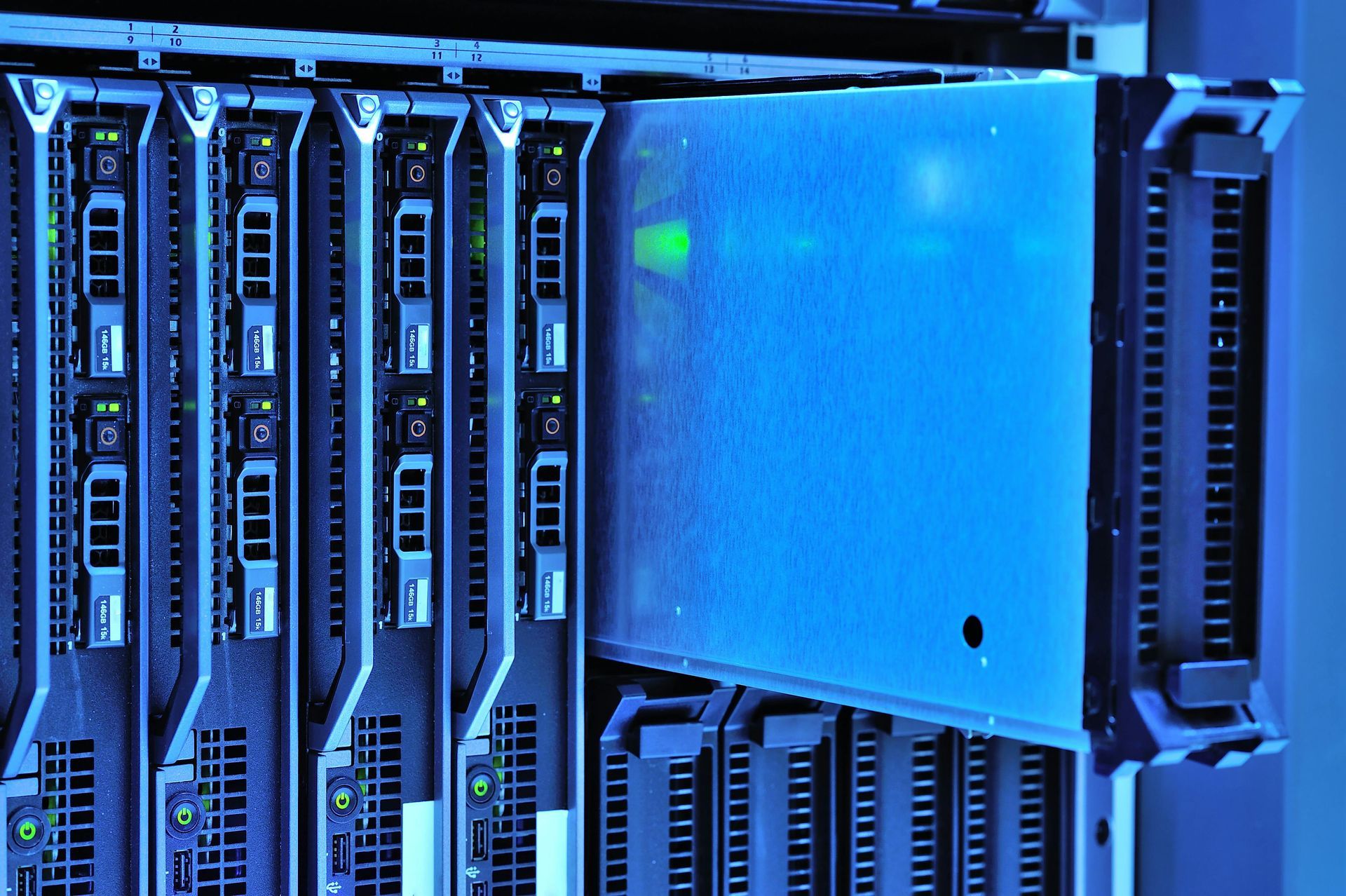 Server racks with a blue-lit server being pulled out of a rack, inside a data center.