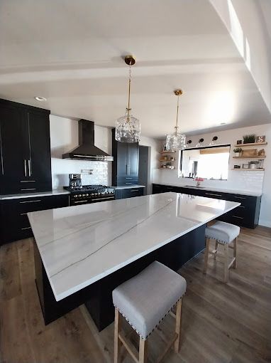 A kitchen with black cabinets and a large white counter top.