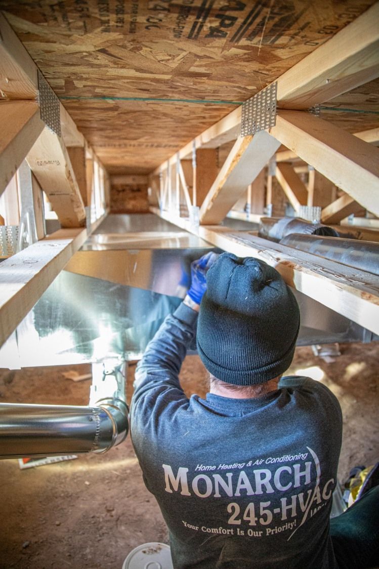 Woman in straw hat smiles, holding wine glass near a lake.