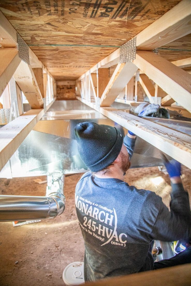 Woman in straw hat smiles, holding wine glass near a lake.