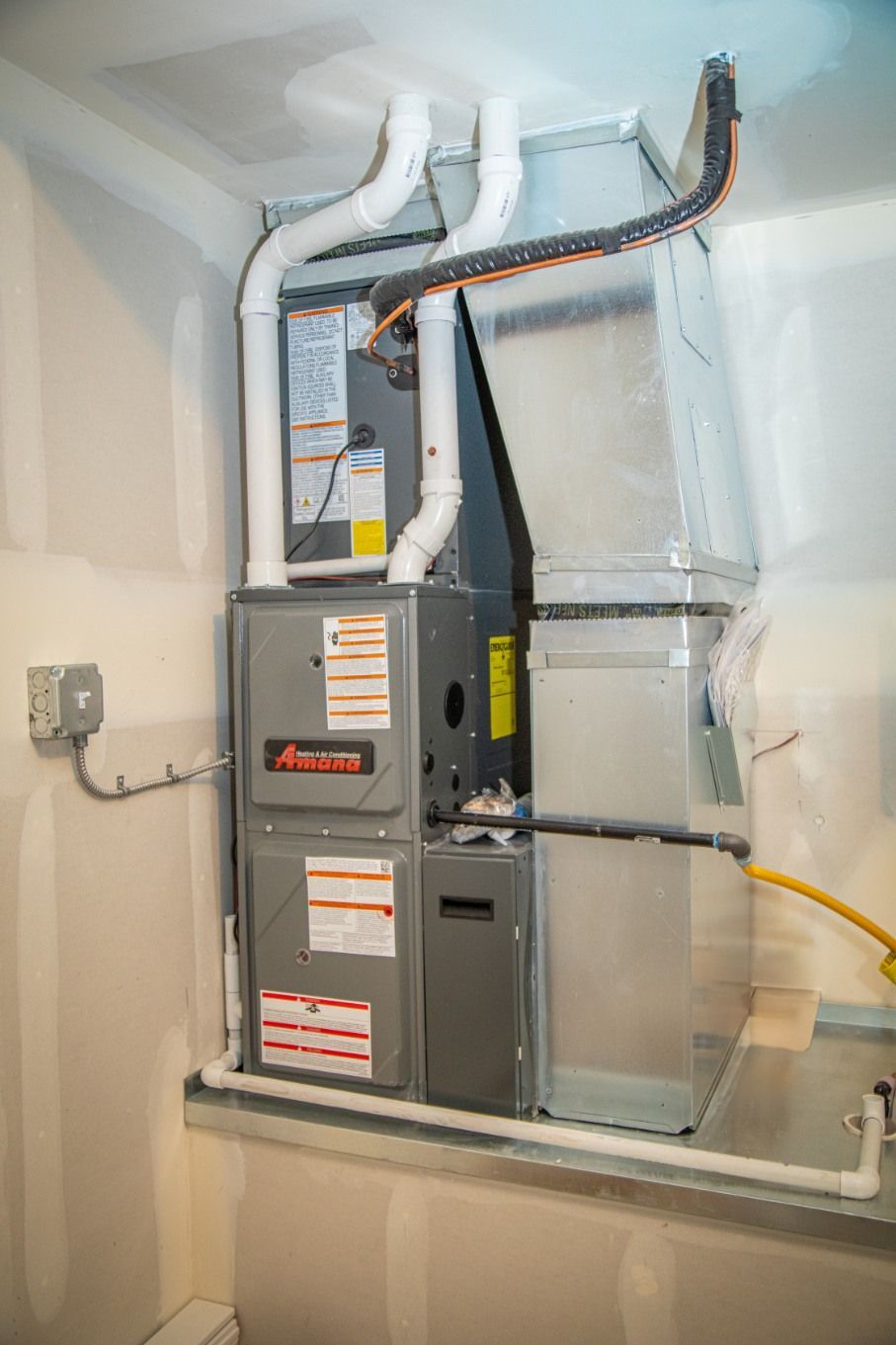 Woman in straw hat smiles, holding wine glass near a lake.