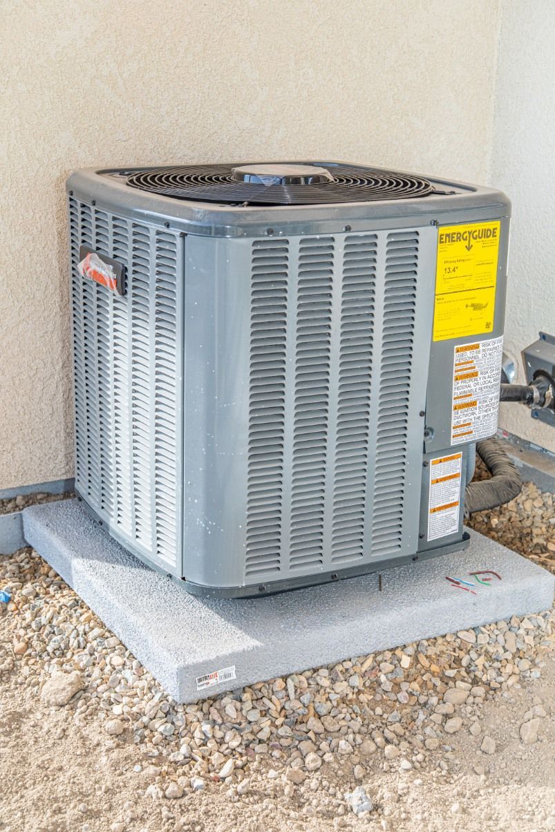 Woman in straw hat smiles, holding wine glass near a lake.