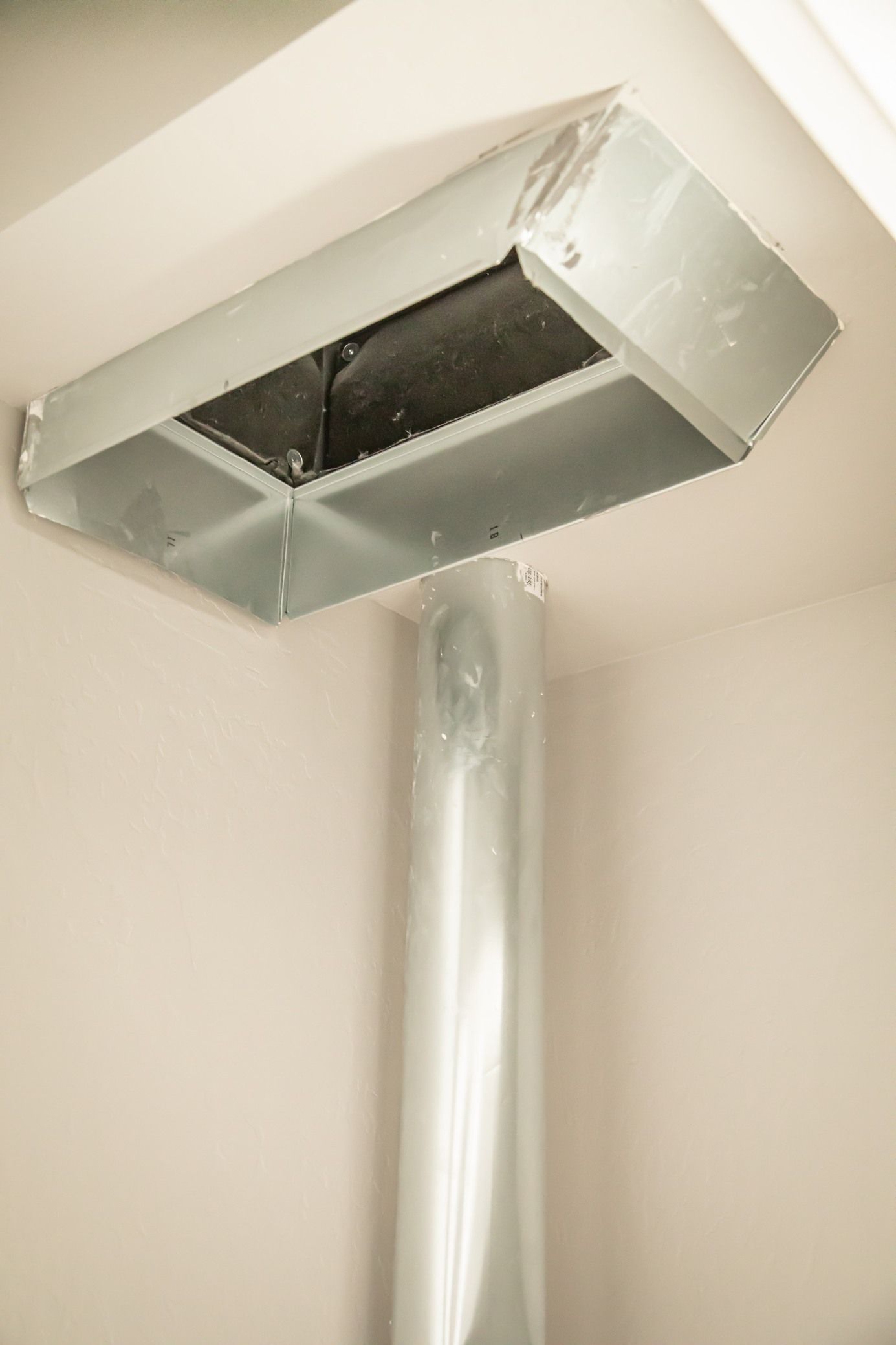 Woman in straw hat smiles, holding wine glass near a lake.