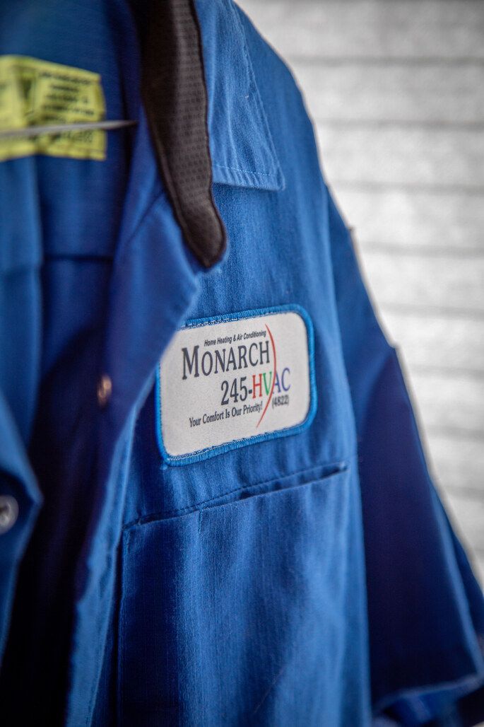 Blue Monarch 245-HVAC work shirt hanging on a wall. White patch with logo on the pocket.