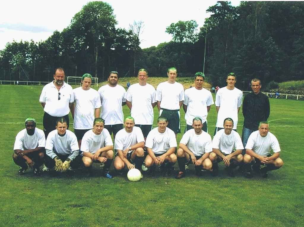 Un groupe d'hommes pose pour une photo dans un champ