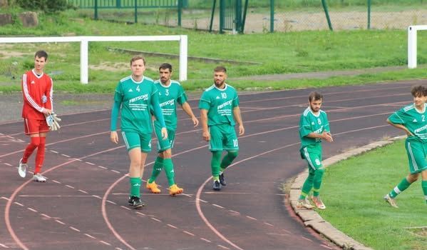 Un groupe d'hommes sont assis sur un banc sur un terrain de football.