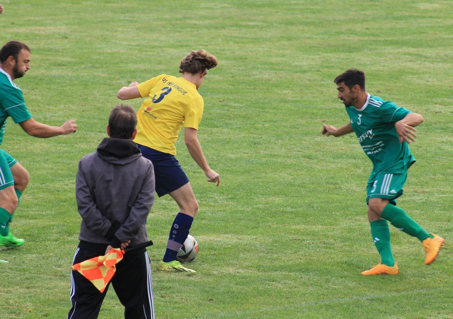 Un groupe d'hommes jouent au football sur un terrain.