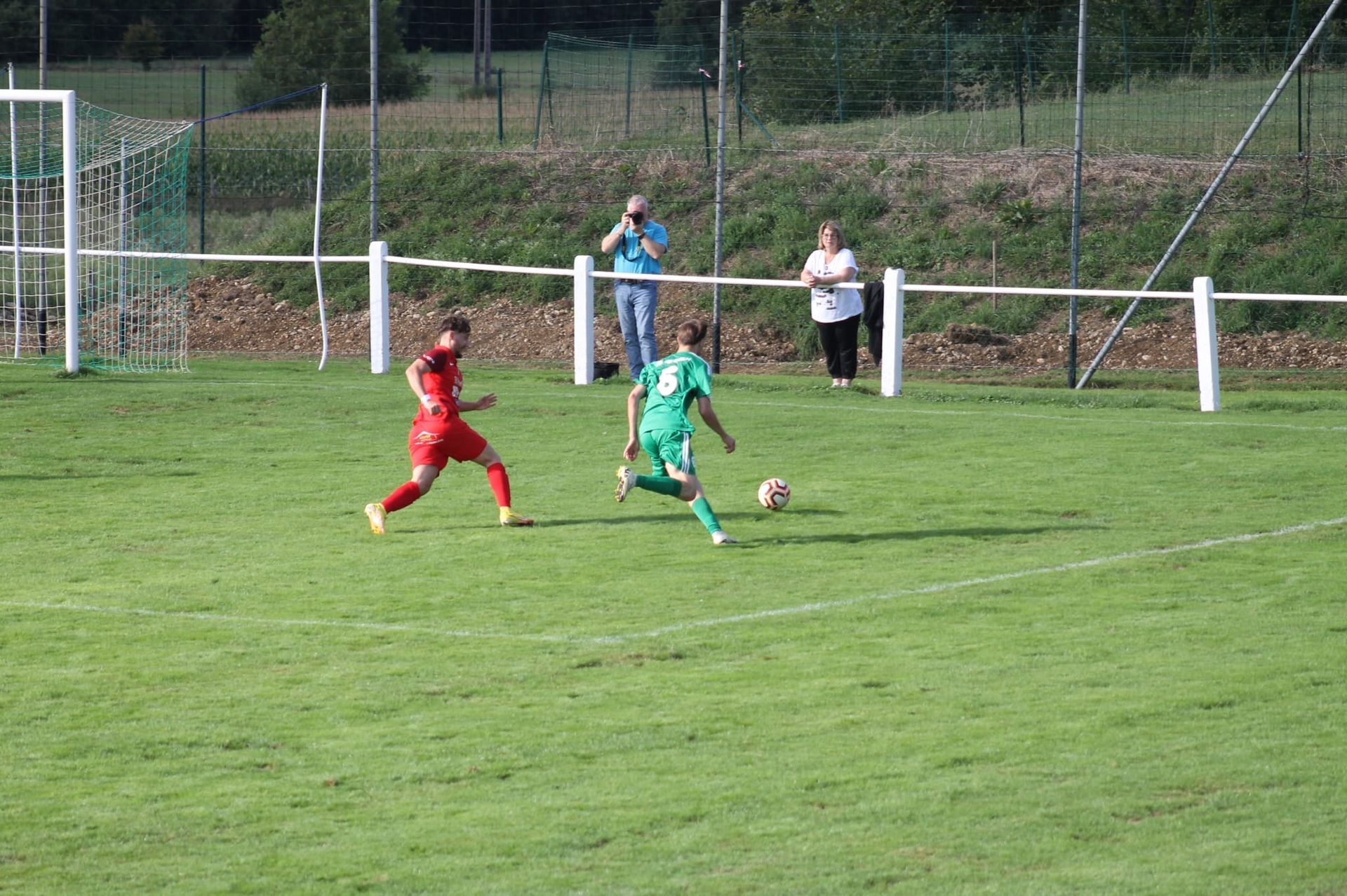 Un groupe de personnes joue au football sur un terrain.