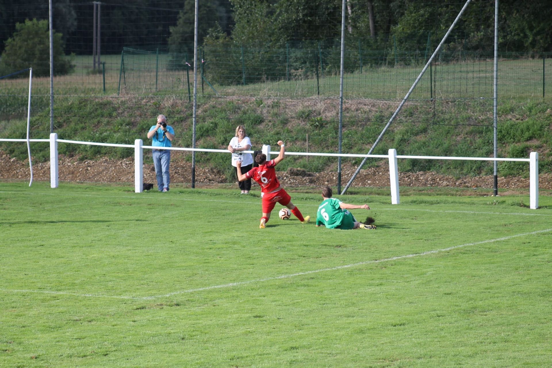 Un groupe de personnes joue au football sur un terrain.