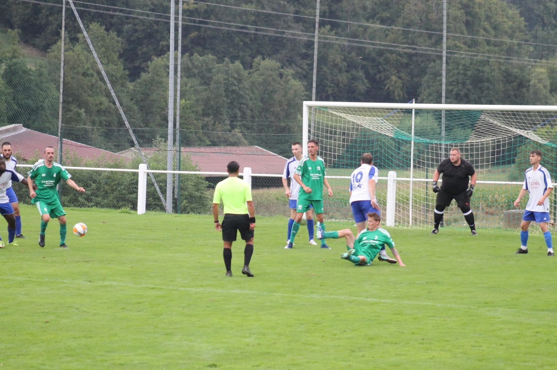 Un groupe de joueurs de football jouent à un jeu sur un terrain.