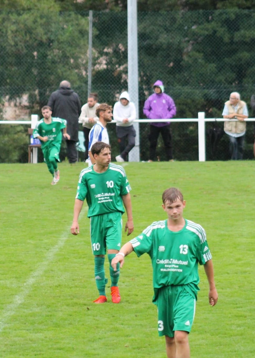 Un groupe de joueurs de football marchent sur un terrain