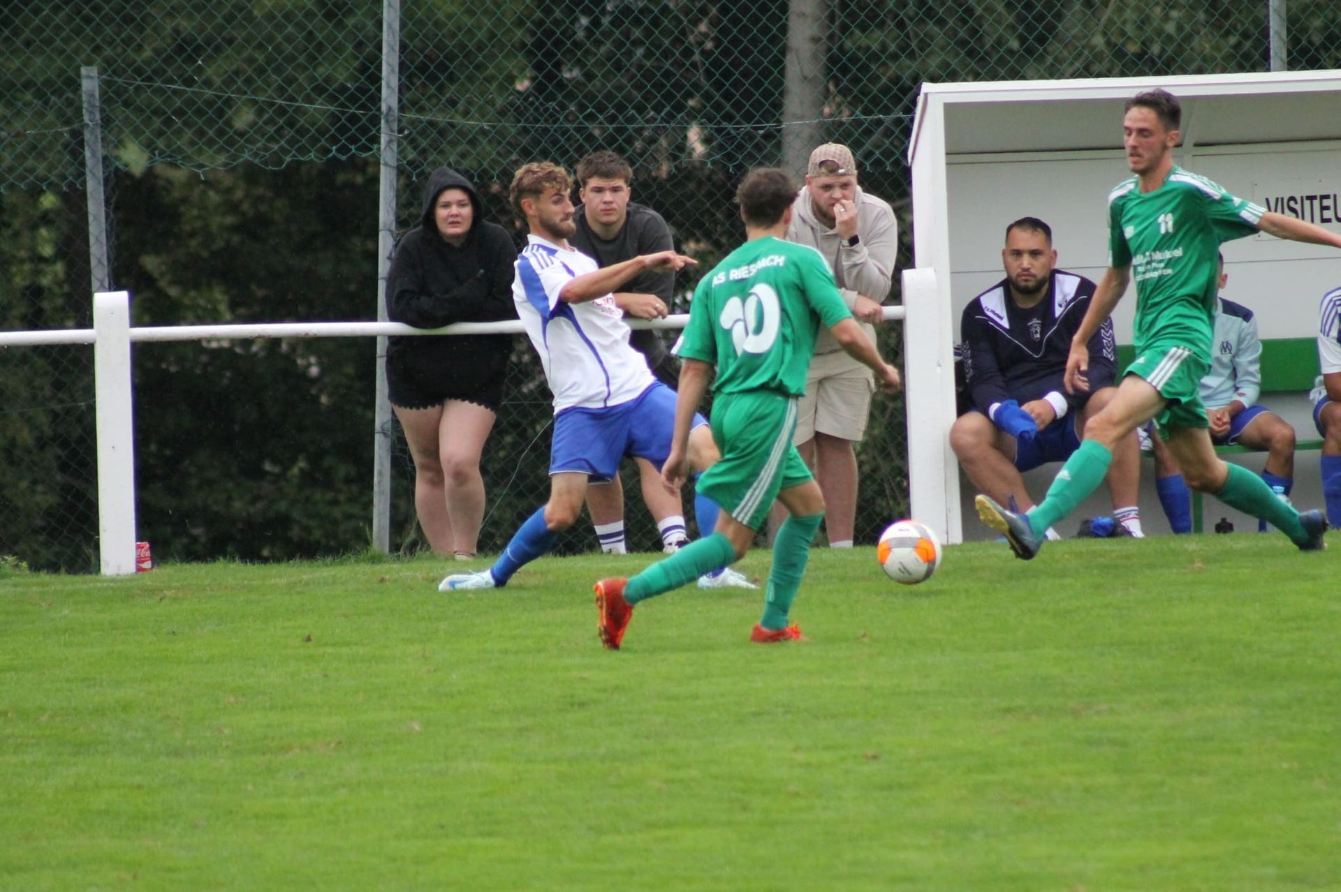 Un groupe de jeunes hommes jouent au football sur un terrain.