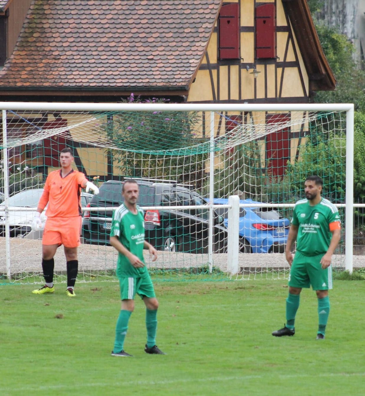 Un groupe de joueurs de football debout sur un terrain devant un but